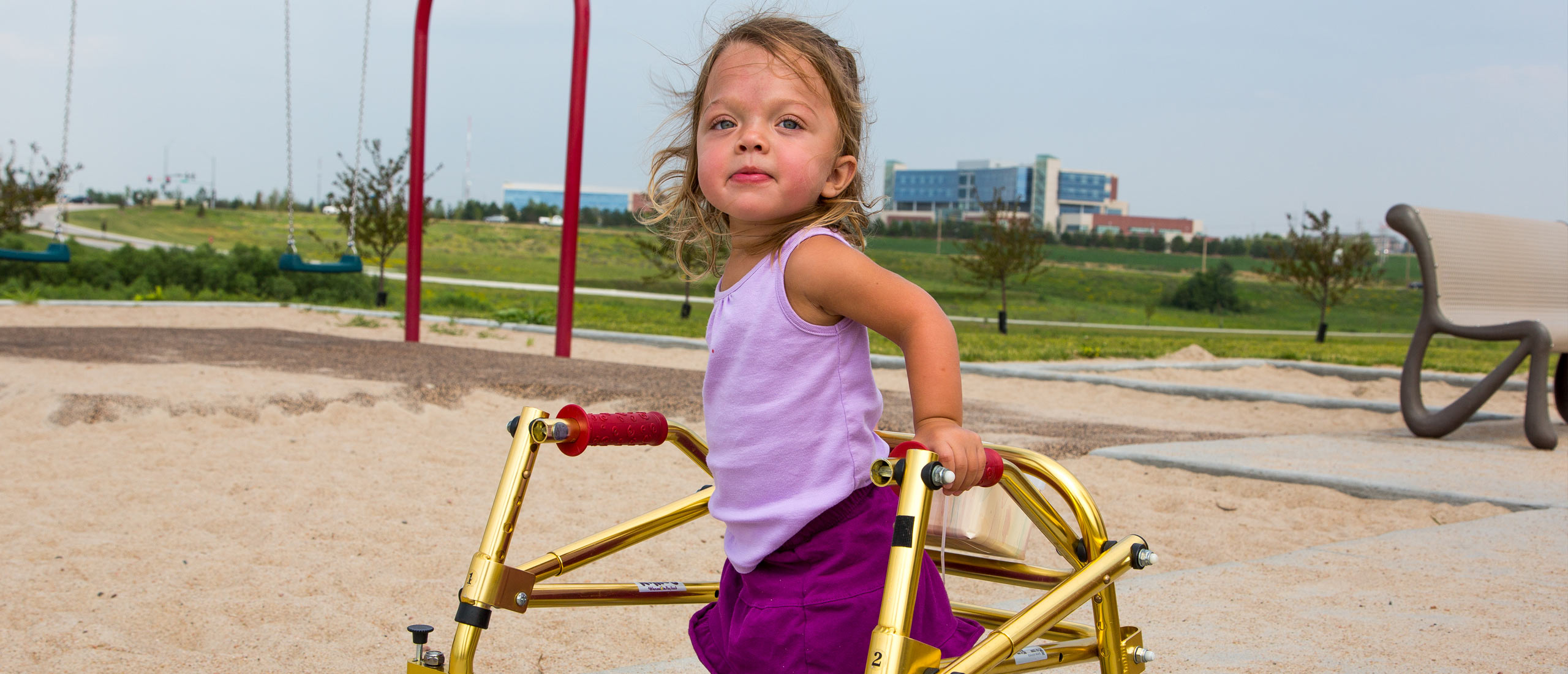 Evie, diagnosed with HPP at 2 weeks old, playing on a playground