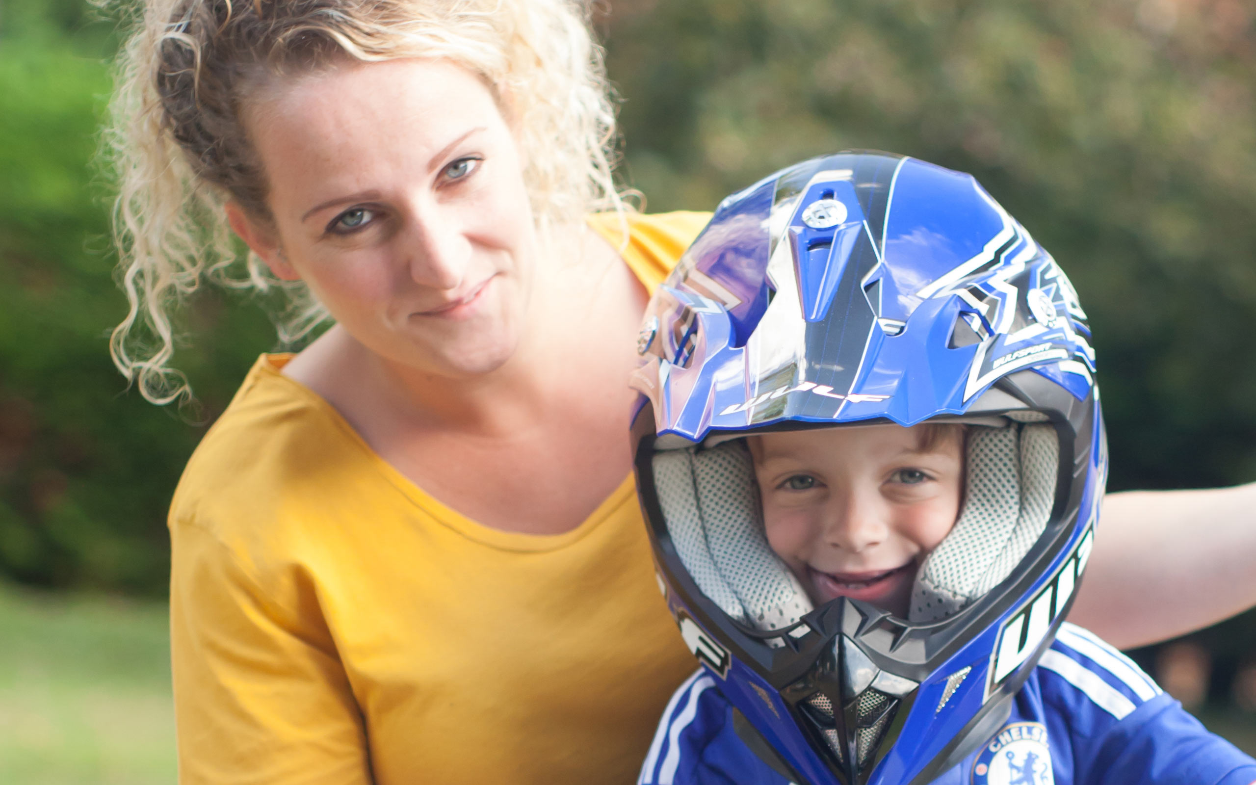 Albie, diagnosed with LAL-D as an infant, wearing a motorcycle helmet with his mother