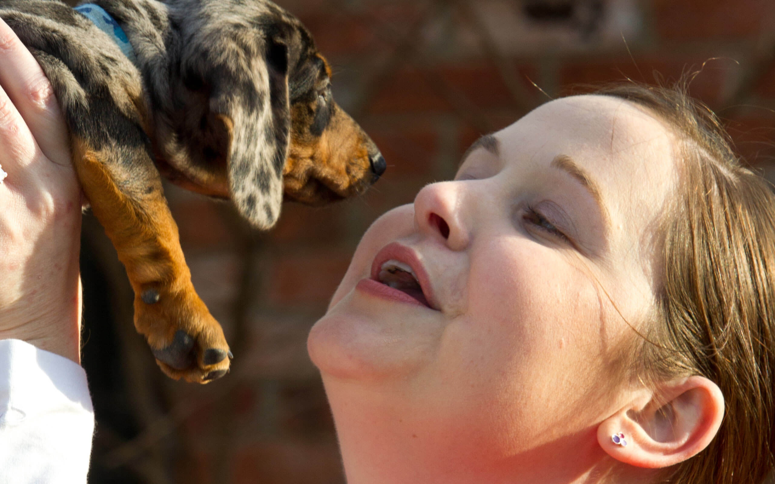 Jill, diagnosed with aHUS at 28 years old, holding a dog