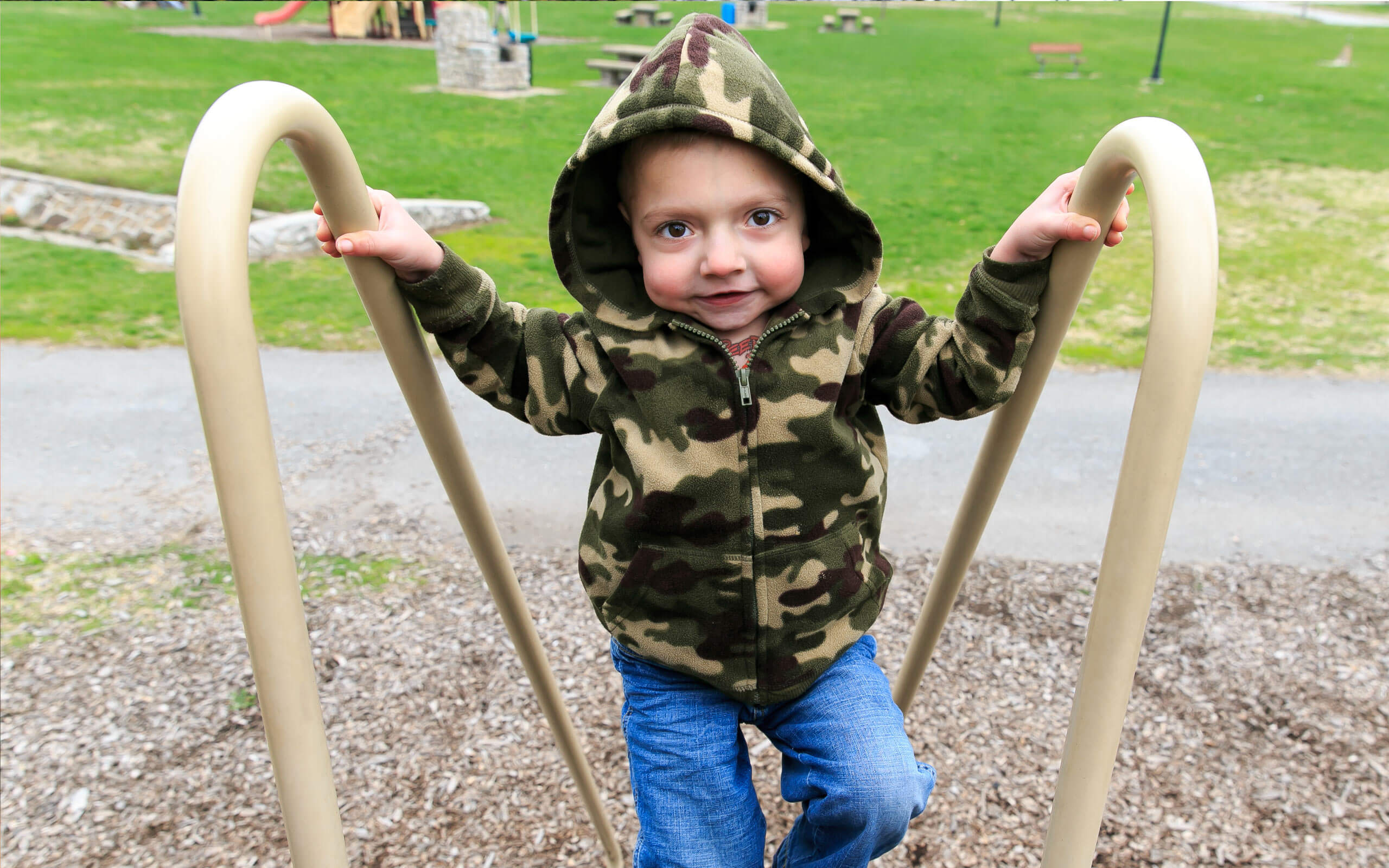 Tanner, diagnosed with HPP at 4 days old, playing on a playground