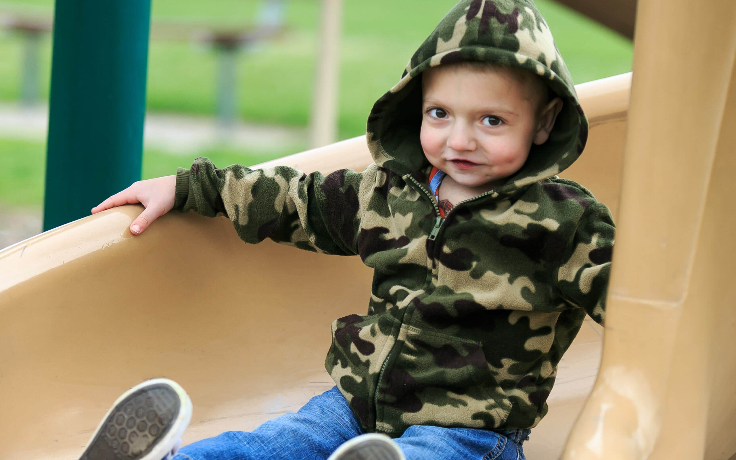 Tanner, diagnosed with HPP at 4 days old, sliding down a slide